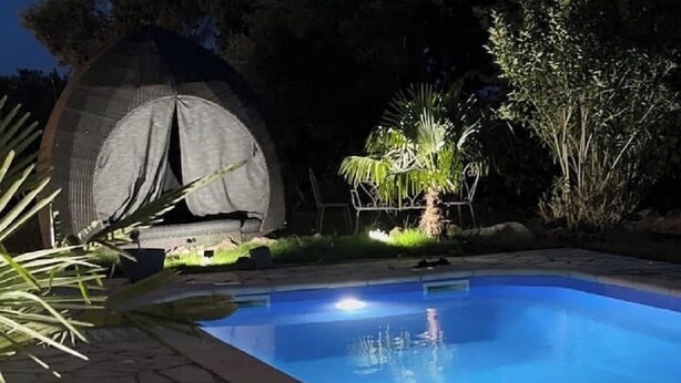 A swimming pool with stone tiles, a fire pit, and a tent in the background. - Maison de 50m2 Avec Piscine Commune (Fréjus)