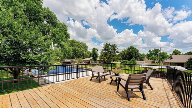 A wooden deck with outdoor furniture, a swimming pool, and a view of a residential area. - TOP-RATED! HOT TUB, KAYAKS, FISHING, BOAT DOCK! Granbury Paddle and Play Escape! (Granbury)