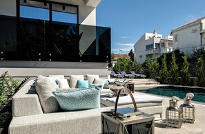 Ein moderner Außenbereich mit Pool, Liegestühlen und zeitgenössischem Design.