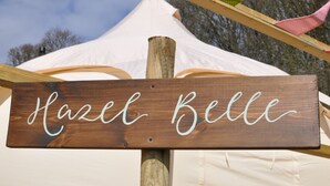 Een houten bord met de naam 'Hazel Belle'.