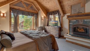 Une chambre confortable avec un grand lit, une commode, une télévision et une cheminée.