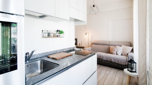 Eine moderne Küche mit Marmorarbeitsplatte, integriertem Spülbecken und Schneidebrett aus Holz.