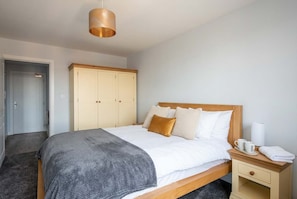 Une chambre à coucher avec un lit, une table de chevet et une armoire.