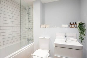 Bathtub, hair dryer, towels, shampoo