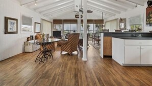 A spacious open-plan living area with a dining table, chairs, and a kitchen area with a bar. - Boaters Paradise  ***Palm Point*** Little Gasparilla North Canal on the POINT (Placida)