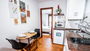 A compact kitchen with a dining area, a microwave, a sink, and a small refrigerator. - Marbella Village | Studio with balcony (Marbella)