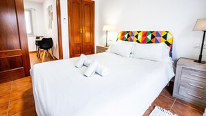 A hotel room with a large bed, wooden wardrobe, and a desk with a chair. - Marbella Village | Studio with balcony (Marbella)