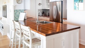 A modern kitchen with white cabinetry, a stainless steel refrigerator, a wooden countertop, and a built-in sink. - 3 Bed~3 Bath~Sleeps 8~Duneridge Condo~Wrightsville Beach, NC (Wrightsville Beach)