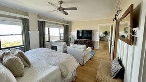 A hotel room with a large bed, a TV, a balcony, and a view of the beach. - 3 Bed~3 Bath~Sleeps 8~Duneridge Condo~Wrightsville Beach, NC (Wrightsville Beach)