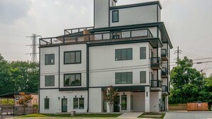 Ein mehrgeschossiges Gebäude mit flachem Dach, großen Fenstern und einem Balkon im oberen Stockwerk.
