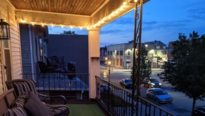 A covered outdoor seating area with wicker furniture and string lights.