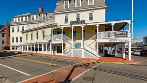 A multi-story building with a prominent 'Atlantic' sign, a covered porch, and a 'Shops' sign advertising art gifts.