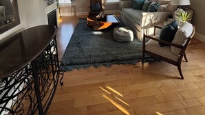 A modern living room with a sofa, coffee table, and a TV mounted on the wall.