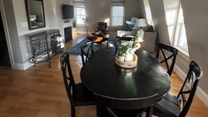 A spacious living area with a dining table, chairs, and a TV.