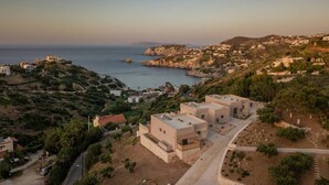 A coastal residential area with modern houses, a clear view of the sea, and a hilly landscape. - Sea View Villa w/Private Pool, 400m to the beach (Heraklion, Crete)