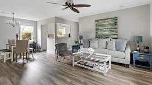 En moderne stue med sofa, sofabord og spiseplads.