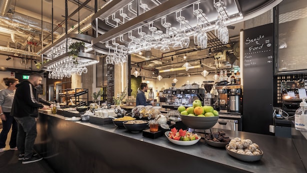 Una zona de menjar a buffet amb diversos plats i un cartell que mostra opcions de snacks i aliments.