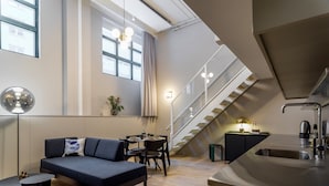 Un apartament modern amb zona de estar, menjador i cuina.