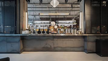 Een moderne keuken met roestvrijstalen apparatuur, een beton aanrechtblad en hangende pendelverlichting.