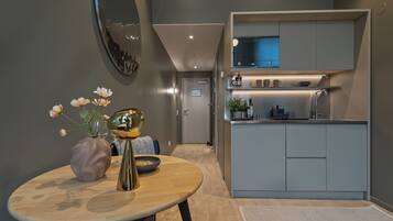 A modern kitchen with grey cabinets, a built-in microwave, and a small countertop.