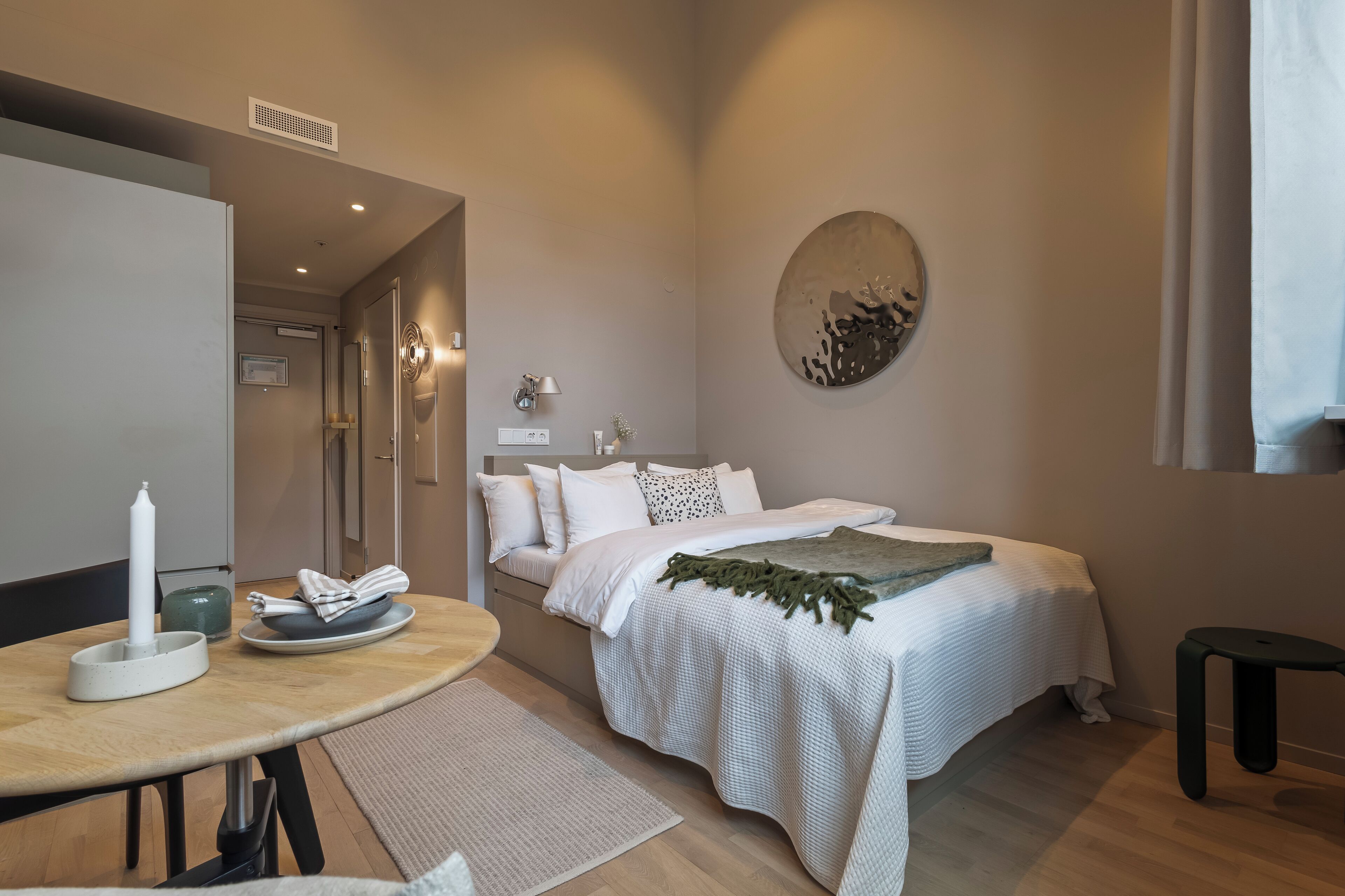 Une chambre à coucher moderne avec un lit, une table de chevet et une œuvre d’art accrochée au mur.