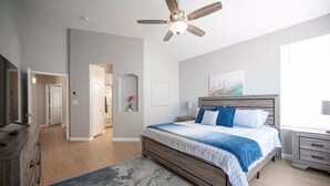 A bedroom with a wooden bed, a ceiling fan, a nightstand, and a window. - 35% off Special Green Valley Gem! 3/2 Single Story (Henderson)