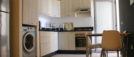 Kylskåp, grytor/köksredskap och matbord