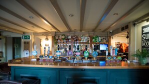 A bar area with a variety of beer taps and a television screen. - The Brewers Inn (Cambridge)