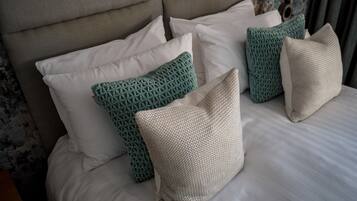A bed with multiple pillows, including patterned and textured designs.