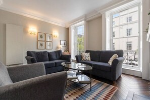 A living room with two sofas, a coffee table, and a patterned rug.