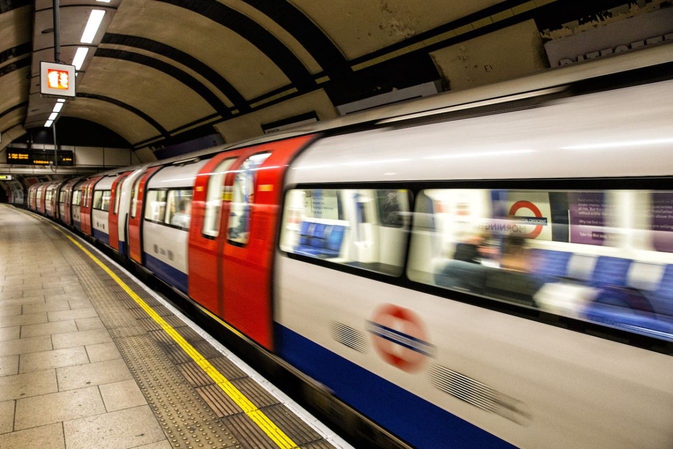 A train in motion at a station platform.