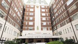 Un edificio de varios pisos con una entrada central identificada como "NELL GWYNN HOUSE".