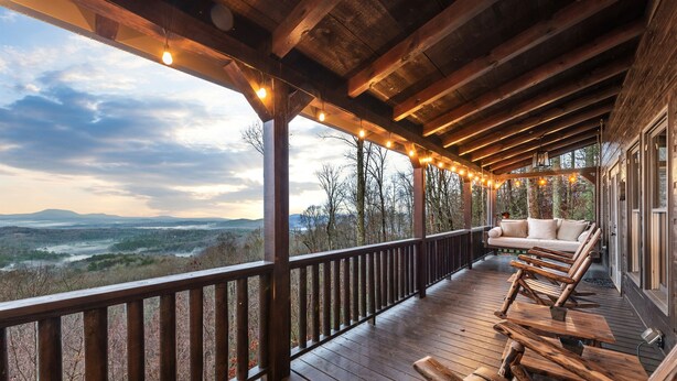 A wooden deck with a sofa and benches, overlooking a forested landscape. - Fab-VIEW-lous 4-bdrm cabin w/ Hottub, LUX theater, outdoor fireplace & firepit (Morganton)