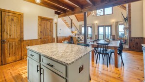 A spacious kitchen with granite countertops, wooden cabinets, and a central island. - Fab-VIEW-lous 4-bdrm cabin w/ Hottub, LUX theater, outdoor fireplace & firepit (Morganton)