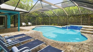 A covered outdoor swimming pool with lounge chairs and a glass-enclosed patio area. - Tranquil Vero Beach Home – Private Pool + Special Booking Discounts! (Vero Beach)
