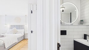 A modern bedroom with a bed, bedside table, and a nightstand.