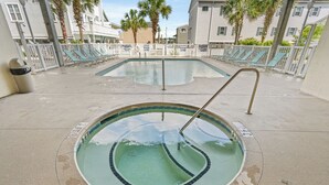 Una piscina con indicador de profundidad de 90 centímetros, rodeada de sillas de descanso y una valla blanca.