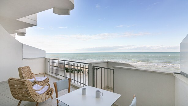 A balcony with wicker chairs, a table, and two white mugs. - Rivazzurra Homes - 3 (Termoli)