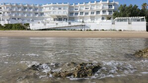 A beachfront hotel with a white facade, multiple balconies, and a clear view of the sea. - Rivazzurra Homes - 3 (Termoli)