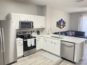 Fridge, stovetop, dishwasher, coffee/tea maker