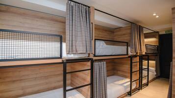 Una habitación con literas, paredes de madera y cortinas.