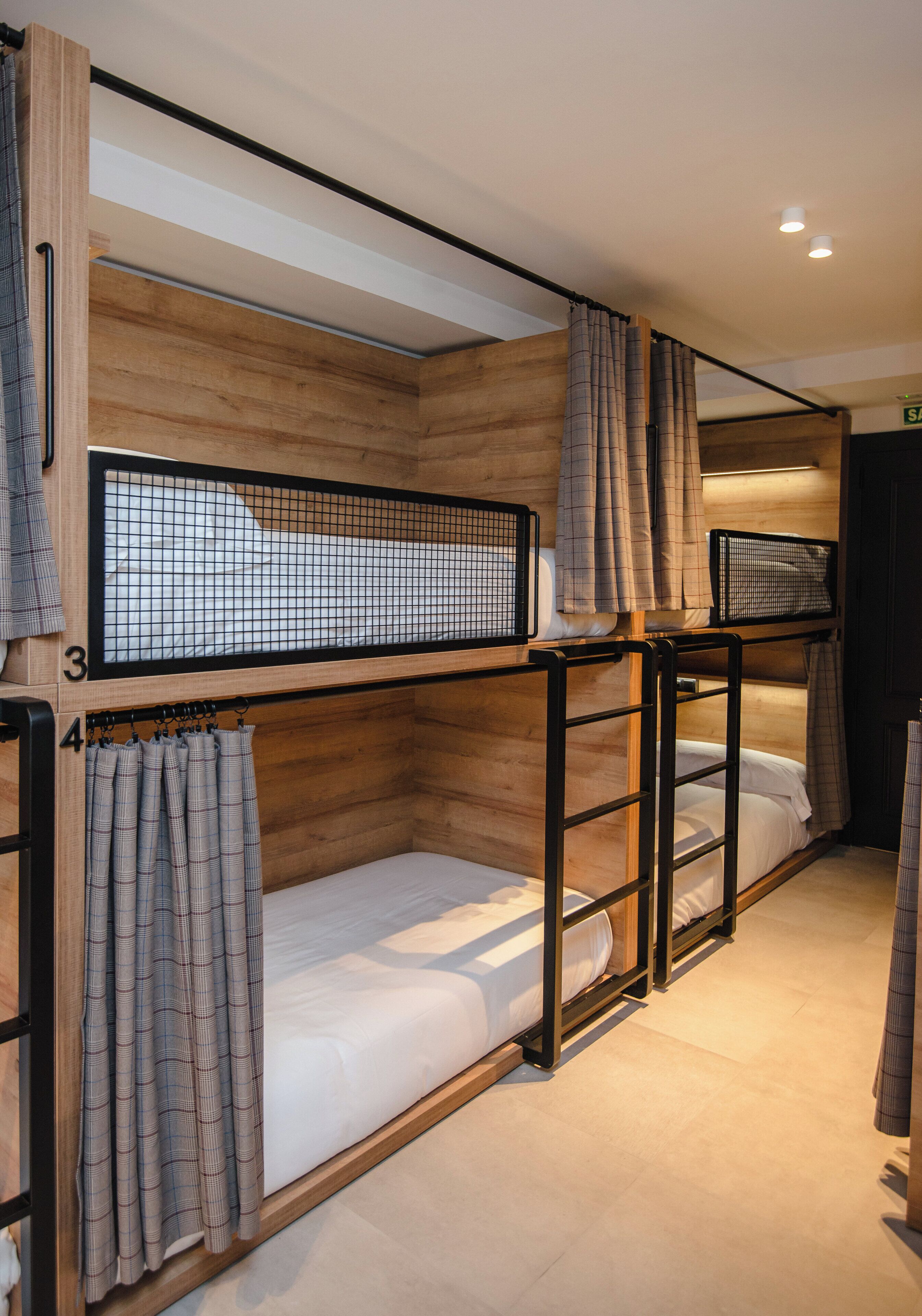 A bunk bed room with wooden walls and metal railings.
