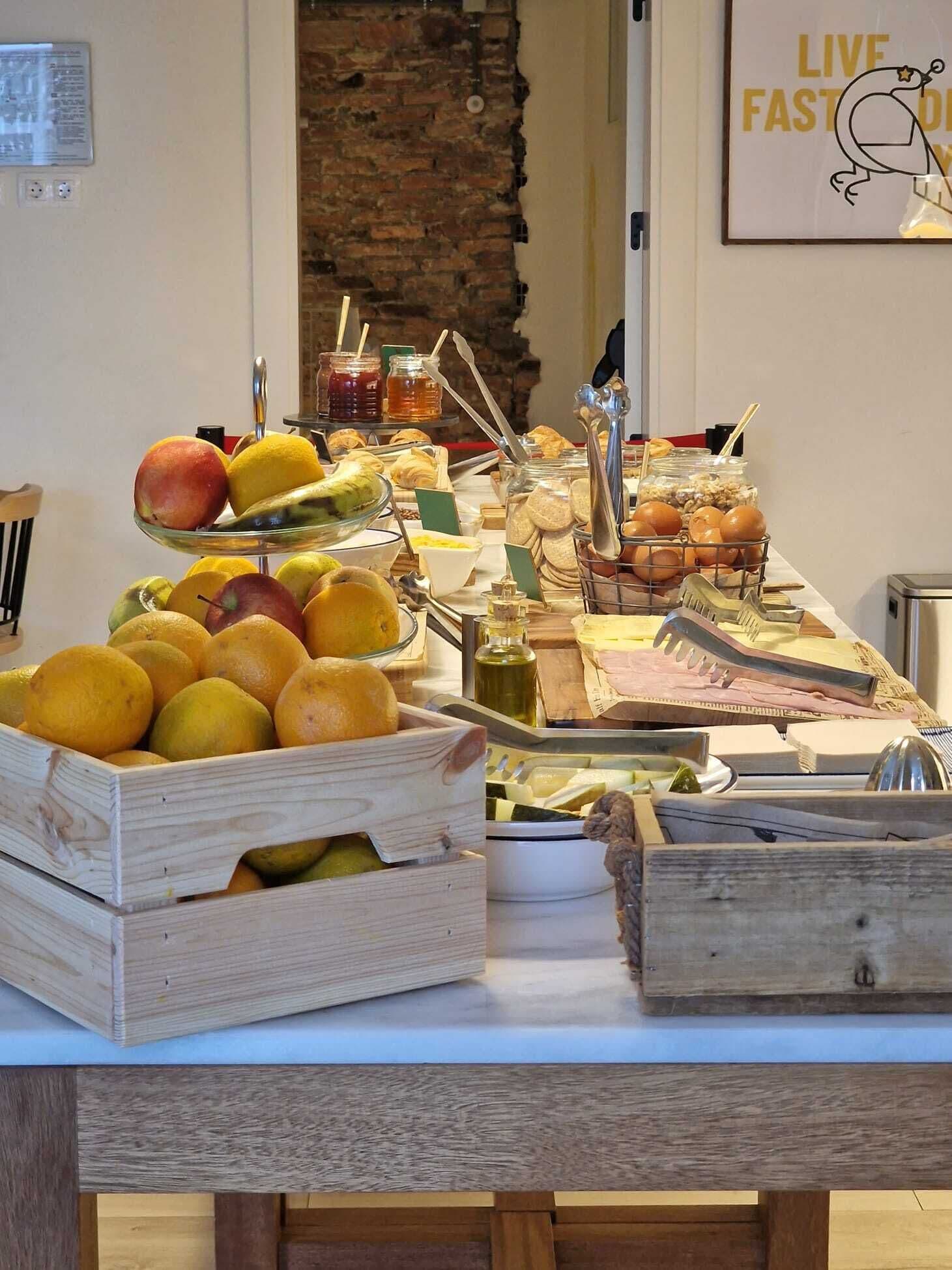Ein Buffet mit Früchten, Brot und Beilagen.