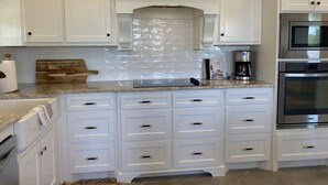 A kitchen with white cabinetry, a granite countertop, a stainless steel oven, and a microwave. - Close to Baylor & Silos: 3 BR Home Pickleball Court, Ping Pong Table & Barn (Lorena)