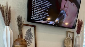 A fireplace with a white brick surround and a wooden mantel shelf. - Close to Baylor & Silos: 3 BR Home Pickleball Court, Ping Pong Table & Barn (Lorena)