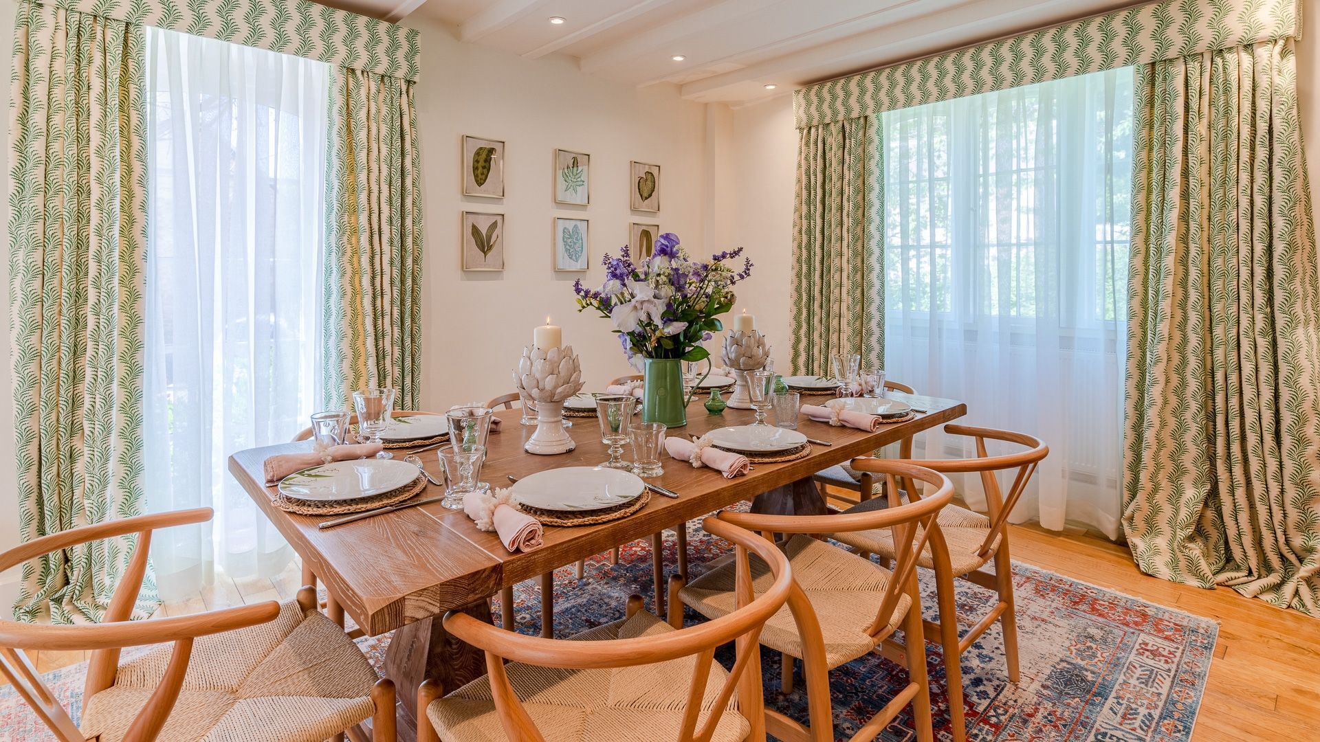Comedor con una mesa de madera dispuesta para seis personas, rodeado de sillas de mimbre.