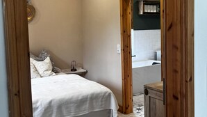 A bedroom with a bed, a nightstand, and a dresser. - Ferienwohnung an der Ostsee (Hasselberg)