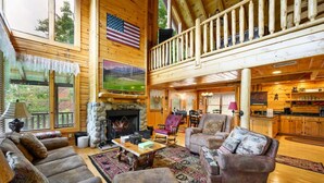 A spacious log cabin with a fireplace, comfortable seating, and a kitchen area. - "Shine Valley #53" View for days (sevierville)