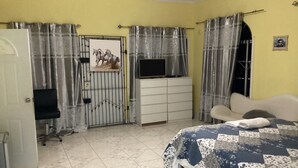 Une chambre à coucher avec un lit, un bureau, une chaise et une armoire.
