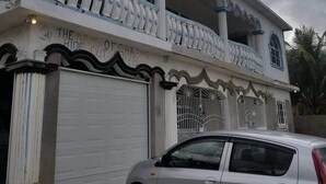 Un bâtiment à deux étages doté d’un balcon, de colonnes et d’une porte de garage.